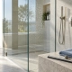 Illustration of a frameless shower screen with water droplets, a squeegee and folded microfiber
