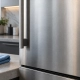Illustration of a brushed stainless refrigerator exterior beside a folded blue microfiber cloth